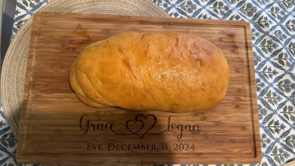 Freshly baked homemade white bread loaf on a wooden cutting board