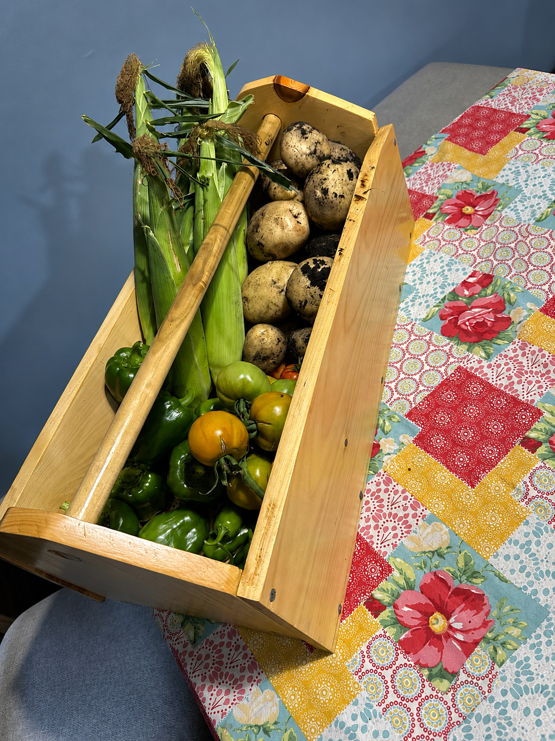Wooden garden harvest tote filled with fresh vegetables from our home garden